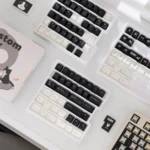 Distinctive Cow Cat PBT Keycap Set for custom keyboards, showcasing artistic black and white designs and playful cow cat motifs from various angles.