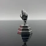 Close-up, angled view of the pure silver Johnny Silverhand cyberpunk artisan keycap, emphasizing its intricate cybernetic arm and dystopian metallic design.