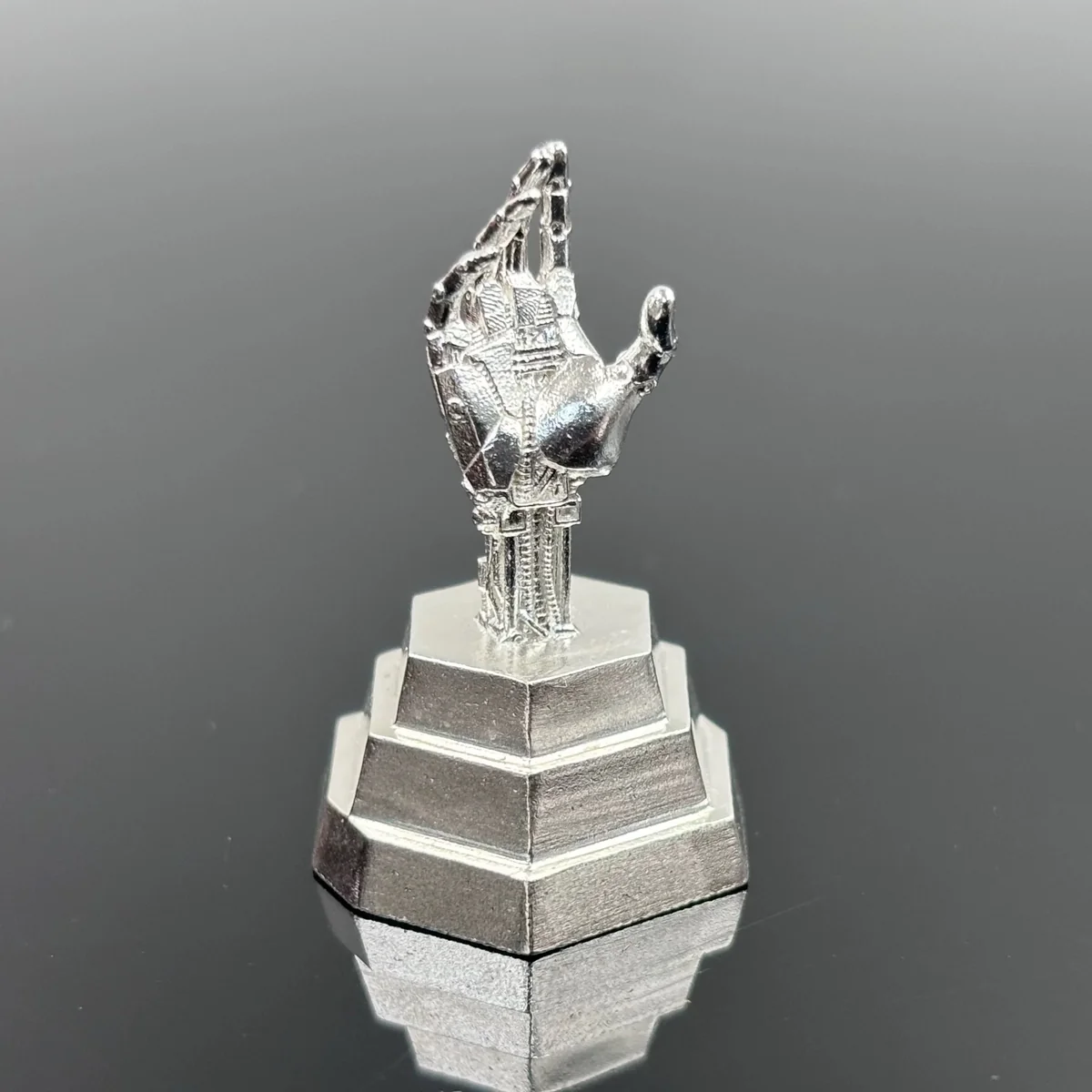 Close-up of a premium pure silver Cyberpunk artisan keycap, showcasing Johnny Silverhand's iconic cybernetic arm with intricate gritty detailing.