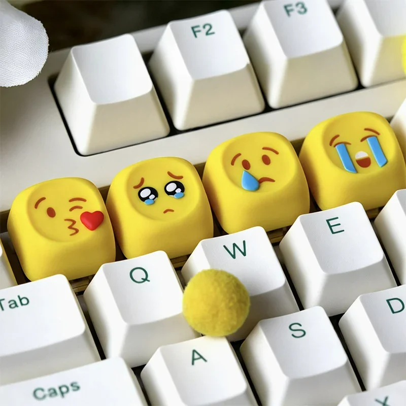 A delightful collection of playful handcrafted resin emoji keycaps, displayed from multiple angles to showcase their vibrant expressions, glossy finish.
