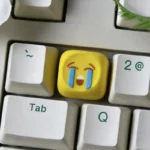 Vibrant and glossy handcrafted resin emoji keycaps, including custom ESC, shown from multiple playful angles. Perfect for personalized keyboard expression.