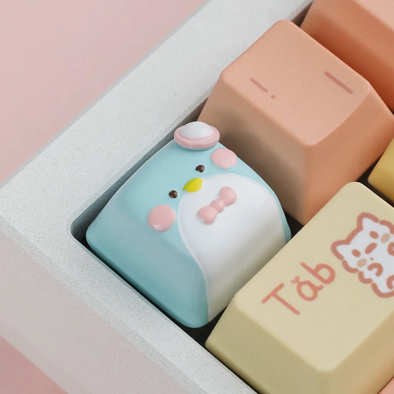 Close-up of a unique handcrafted artisan resin gentleman penguin keycap, revealing its elegant design for the ESC key from a new personality setup.