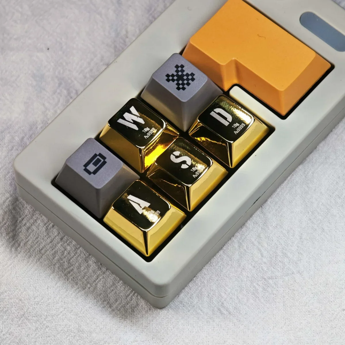 Close-up views of premium metallic gold WASD gaming keycaps, highlighting their gleaming finish and robust, luxury design from various angles.