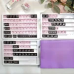 Detailed view of a transparent PC keycap set, showcasing its intricate black and pink graffiti art and vibrant, edgy street style.