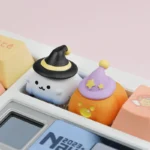 Close-up of a handcrafted resin Halloween artisan keycap, showcasing charming ghost and pumpkin sculptures from various artistic angles.