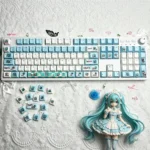 A playful gallery view of vibrant Hatsune Miku Q-version PBT backlit keycaps set, showcasing chibi art and illuminated legends from various angles.