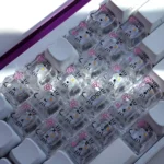 A playful set of Hello Kitty glitter backlit PC keycaps set, showcasing transparent designs with cute cat faces and sparkling hearts shaped design.