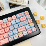 Close-up of a section of the iconic Hello Kitty MOA PBT dye-sub keycaps set, highlighting the vibrant pink and white playful iconography from the 130-key.