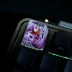 Close-up of the hand-painted translucent Hornet Hollow Knight ESC keycap, highlighting the intricate glowing details and dark fantasy artistry.