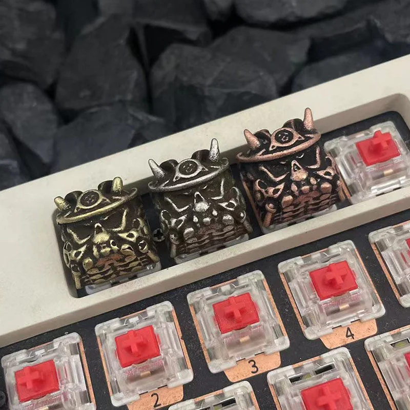 A close-up view of the handcrafted Japanese Oni Keycap, showcasing its striking samurai mask design and detailed vintage finish from a unique angle.