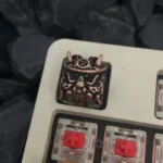 Close-up of a premium handcrafted vintage copper Japanese Oni keycap, featuring intricate samurai mask details for mechanical keyboard enthusiast.