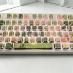 Jasmine PBT keycaps set in a gallery view, showcasing translucent side-engraved legends and delicate jasmine florals from various artistic angles.