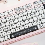 A close-up of the playful line art cat PBT MAO profile keycaps set, showcasing the whimsical minimalist designs from various angles. The durable PBT material.