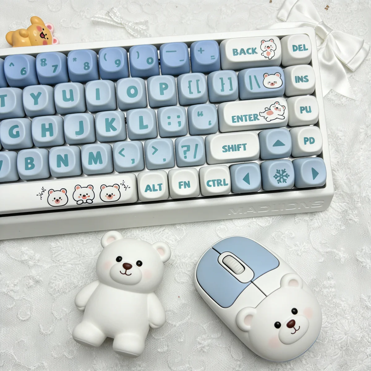 A close-up view of several Playful Little Bear PBT MOA ergonomic keycaps set, showcasing their adorable white bear illustrations and gentle charm from various angle.