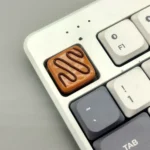 Close-up of a handcrafted gourmet chocolate artisan resin keycap, showcasing warm striped caramel hues, evoking a delicious aesthetic.