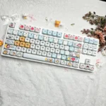 Adorable Maltese PBT MOA keycap set. View charming Maltese dog and playful apple designs from various angles, perfect for a cute, serene keyboard.