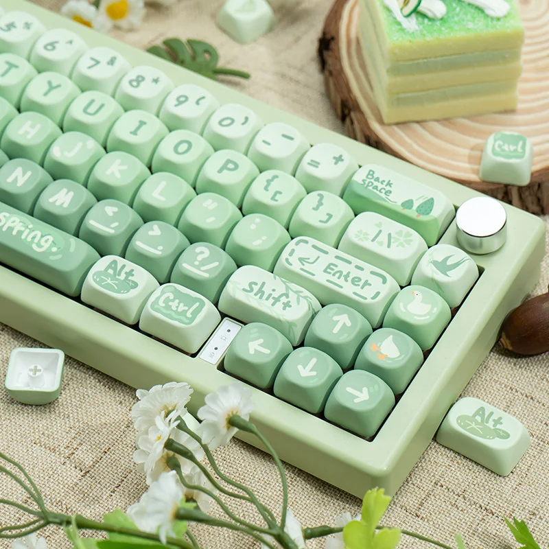 Matcha Green PBT MOA keycaps set with creamy legends, artistically arranged to showcase the unique profile, evoking a playful spring picnic setup.