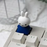 Close-up of an adorable, handcrafted Miffy & Friends resin ESC keycap, showcasing its whimsical design and vibrant colors from multiple angles.
