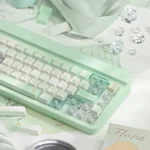 Close-up and wide shots of the ethereal Misty Mint PBT+PC translucent keycaps set, capturing their refreshing hue and serene, misty quality.