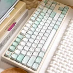Artistic close-up of serene misty mint PBT+PC translucent keycaps set, showcasing their refreshing ethereal glow from an alternate perspective.