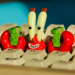 Iconic SpongeBob Mr. Krabs resin artisan keycap, vibrant and intricately detailed with money themes, shown from multiple angles for mechanical keyboard.