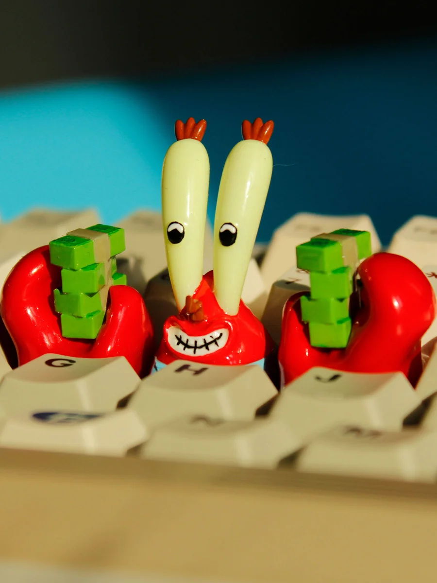 Iconic SpongeBob Mr. Krabs resin artisan keycap, vibrant and intricately detailed with money themes, shown from multiple angles for mechanical keyboard.