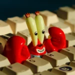 Iconic Mr. Krabs resin artisan keycap for keyboards. See intricate, character-accurate SpongeBob design with vibrant, money-themed details from multiple angles.