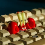 Vibrant SpongeBob Mr. Krabs resin artisan keycap featuring his iconic normal eyes and a playful coin claw, perfect for keyboard enthusiasts.