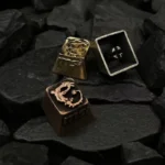 Close-up views of the iconic MSI Logo artisan keycap, showcasing its handcrafted industrial retro design, metallic luster, and detailed brand logo.