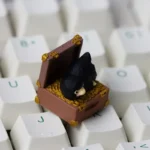 Handcrafted Niffler artisan resin keycap, intricately sculpted, showcasing its whimsical fantasy details and rich dark tones from a unique angle.