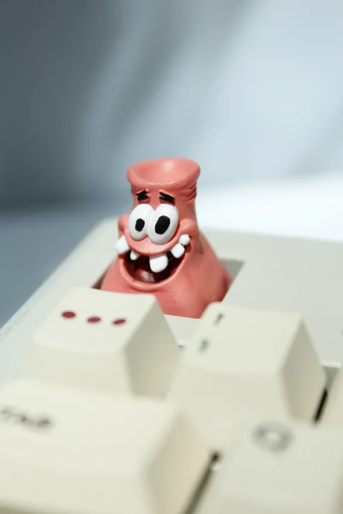 Close-up of a vibrant, handcrafted Patrick Star artisan keycap, an iconic and goofy addition for nostalgic keyboard fun.