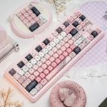 Whimsical pink bear PBT MOA keycap set, showcasing its adorable line art and soft pastel pink from multiple angles. Perfect for a charming desktop.