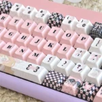 Sweetheart Pink PBT custom keycaps set artfully arranged, highlighting the charming pastel pink shades and playful dye-sub legends from multiple adorable angles.