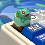 Close-up view of a vibrant artisan Pokemon hatching resin ESC keycap, showcasing intricate handcrafted details and a charming character emerging.
