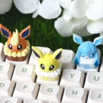 Jolteon Cake Artisan Keycap, an exclusive Eeveelution cake-style Pokemon ESC keycap. This playful design is showcased from multiple whimsical angles.