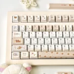 A playful collection of pixel Rilakkuma PBT dye-sub keycaps set, showcasing various adorable characters and cozy designs from different angles, perfect for fans.