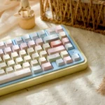 Close-up of a Romance Until Death PBT Dye-Sublimated Keycap Set, highlighting the dreamy pink, blue, and yellow hues arranged artistically.