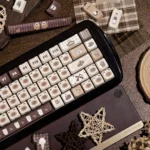 Adorable Siamese Cat Cafe PBT Dye-Sub keycap set, featuring whimsical cat designs and coffee elements from various angles and bathed in warm.