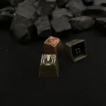 Close-up of a pure copper Spider-Man logo artisan keycap, showcasing its intricate retro design and vintage patina from multiple angles.