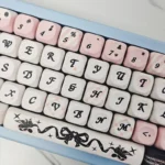 A close-up view of the playful PBT Sweetheart Black Cat Keycap Set, showcasing adorable black cat motifs and heart accents on smooth MOA profile.