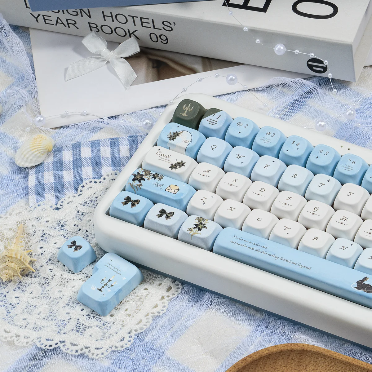 Wild Lily Notebook PBT & Transparent PC keycaps set. Multiple angles showcase delicate floral and vintage journal motifs, with nature's elegance.