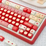 Various angles of the playful 'Apple' UR82 Tri-mode Mechanical Keyboard, highlighting its compact ergonomic design and vibrant RGB lighting.