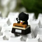 Handcrafted resin artisan cat keycaps collection, featuring whimsical felines expressing relatable work moods from various playful angles.