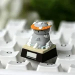 Whimsical resin artisan cat keycap, viewed from multiple angles, featuring an expressive feline illustrating a funny work mood, adding charm to your keyboard.
