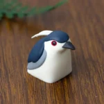 Handcrafted Night Heron artisan keycap, showcasing its intricate resin design and ethereal nature aesthetic from a striking new angle.