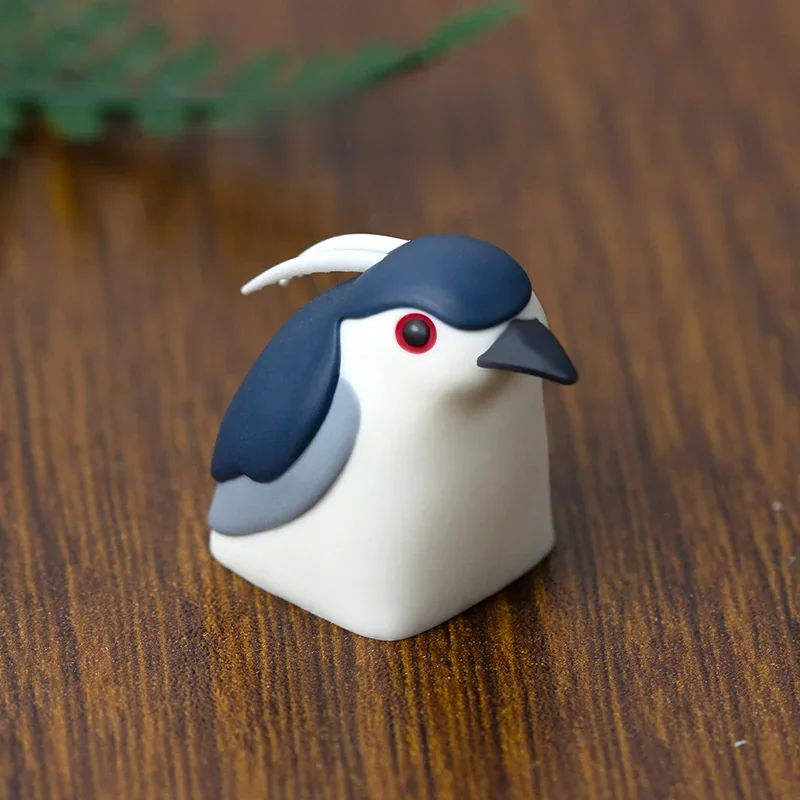 Handcrafted Night Heron artisan keycap, showcasing its intricate resin design and ethereal nature aesthetic from a striking new angle.