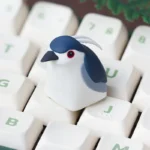Intricate handcrafted Night Heron artisan keycap, made of resin, displaying its ethereal nature aesthetic from a unique angle for custom keyboards.