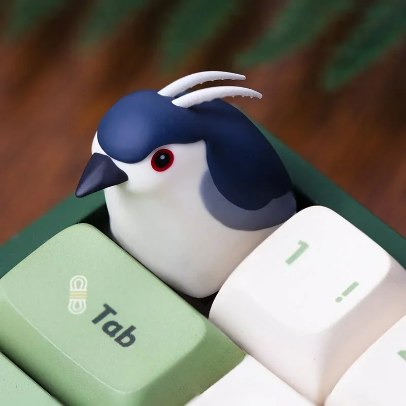 Close-up of the handcrafted resin Night Heron artisan keycap, showcasing its intricate ethereal design from a unique angle, highlighting the delicated design.
