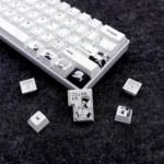 Close-up view of the exclusive Gojo Satoru PBT dye-sub keycaps set, showcasing the sophisticated grey palette and iconic imagery from a unique angle,
