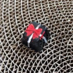 Detailed view of a handcrafted resin gift keycap, showcasing its translucent bowknot and miniature gift box design. An artistic custom ESC keycap.
